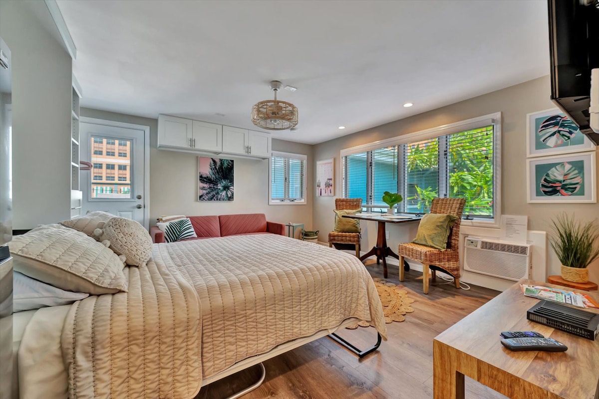 Settle into your bright and cozy retreat, where natural light pours through large windows and lush greenery peeks in. Sink into plush bedding and let the tropical accents and warm wood tones welcome you home.