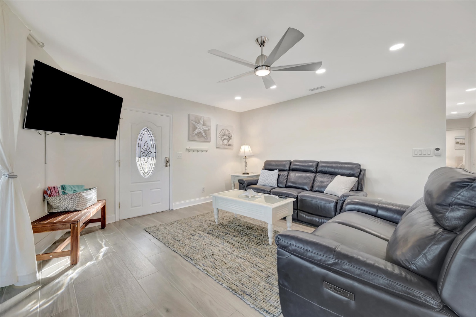 Settle into the plush leather sofas in this bright, airy living room where coastal charm meets comfort. With ample seating and a ceiling fan overhead, your group will have plenty of space to unwind after a day of adventure.
