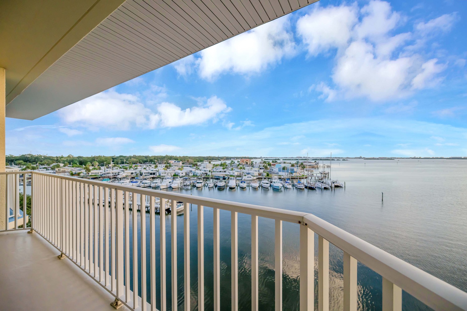 Sweeping marina and waterfront views from your private balcony, where sailboats dot the calm harbor and open skies stretch endlessly above.