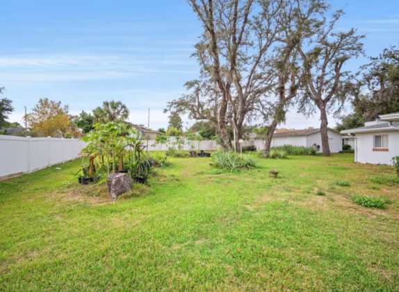 This quiet residential property features a spacious green lawn and mature trees, offering a peaceful neighborhood setting for your stay.