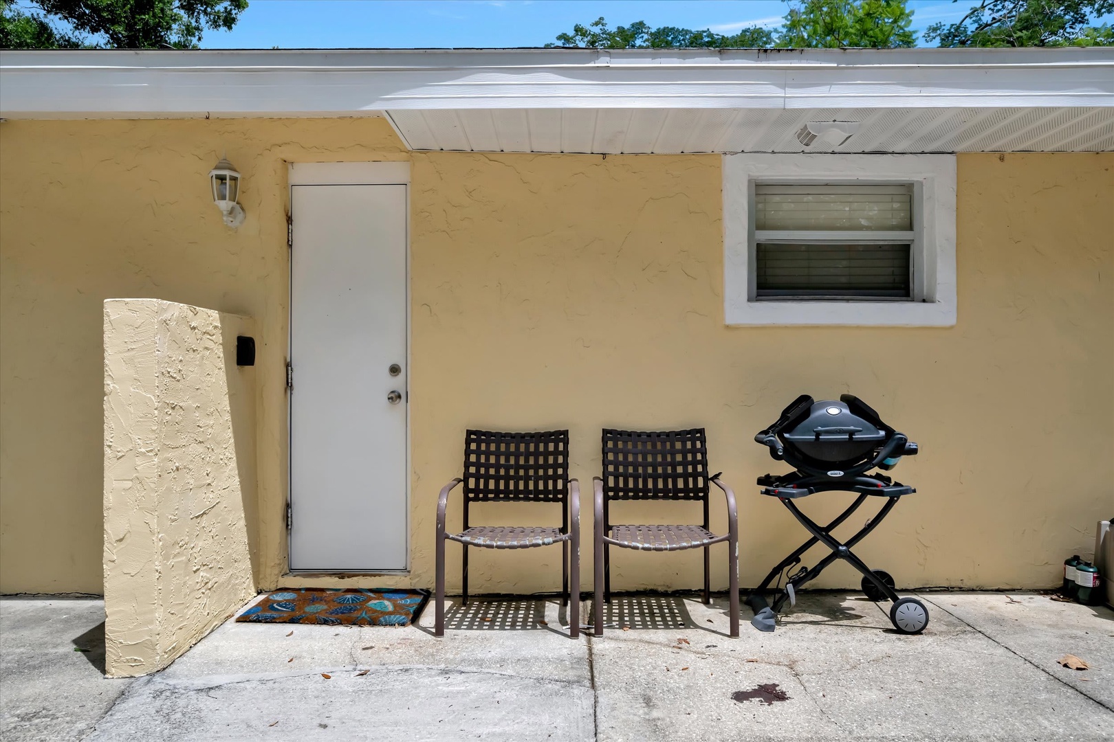Private outdoor patio space with your own grill for cooking up meals in the sunshine. Trees provide natural shade overhead for comfortable afternoons outdoors.