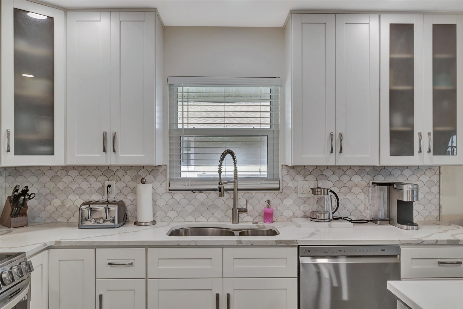 Your modern kitchen awaits with gleaming quartz countertops, a stylish arabesque tile backsplash, and stainless steel appliances ready for preparing memorable vacation meals.