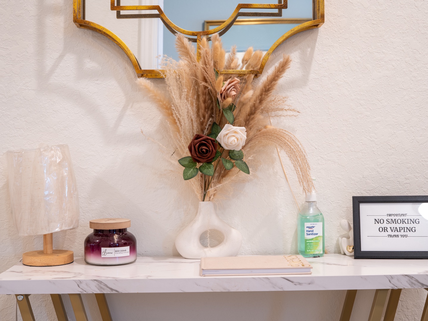 Step into your thoughtfully appointed space where every detail welcomes you. A marble-topped table greets you with a vase of soft pampas and roses, alongside a refreshing hand sanitizer for your peace of mind.
