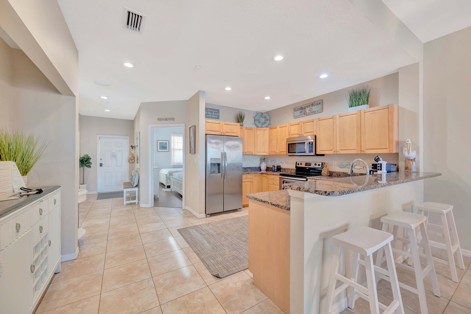 Step into your light-filled open kitchen with granite counters, stainless appliances, and breakfast bar seating perfect for morning coffee or casual meals with family.