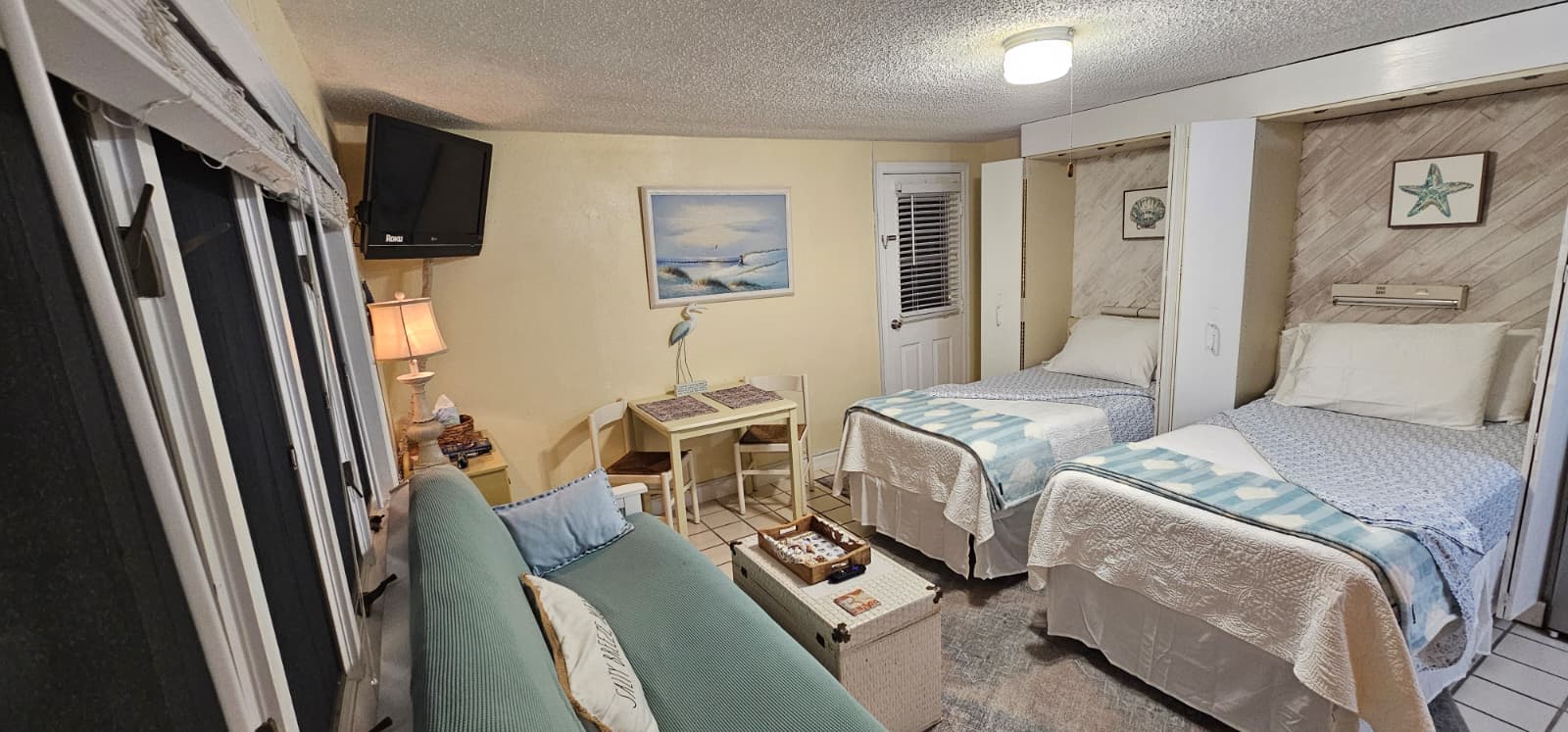 Your coastal retreat awaits with two comfortable beds, a cozy seating area, and cheerful beach-inspired décor to help you unwind after a day of sun and surf.