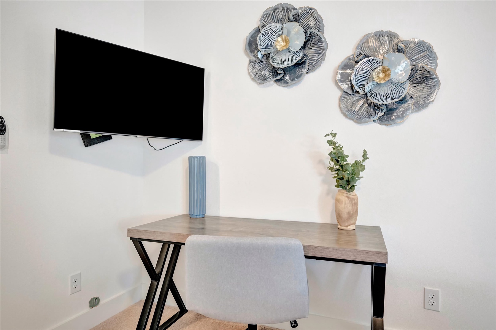 A stylish workspace awaits, featuring modern décor and a wall-mounted TV to keep you entertained or productive during your stay.