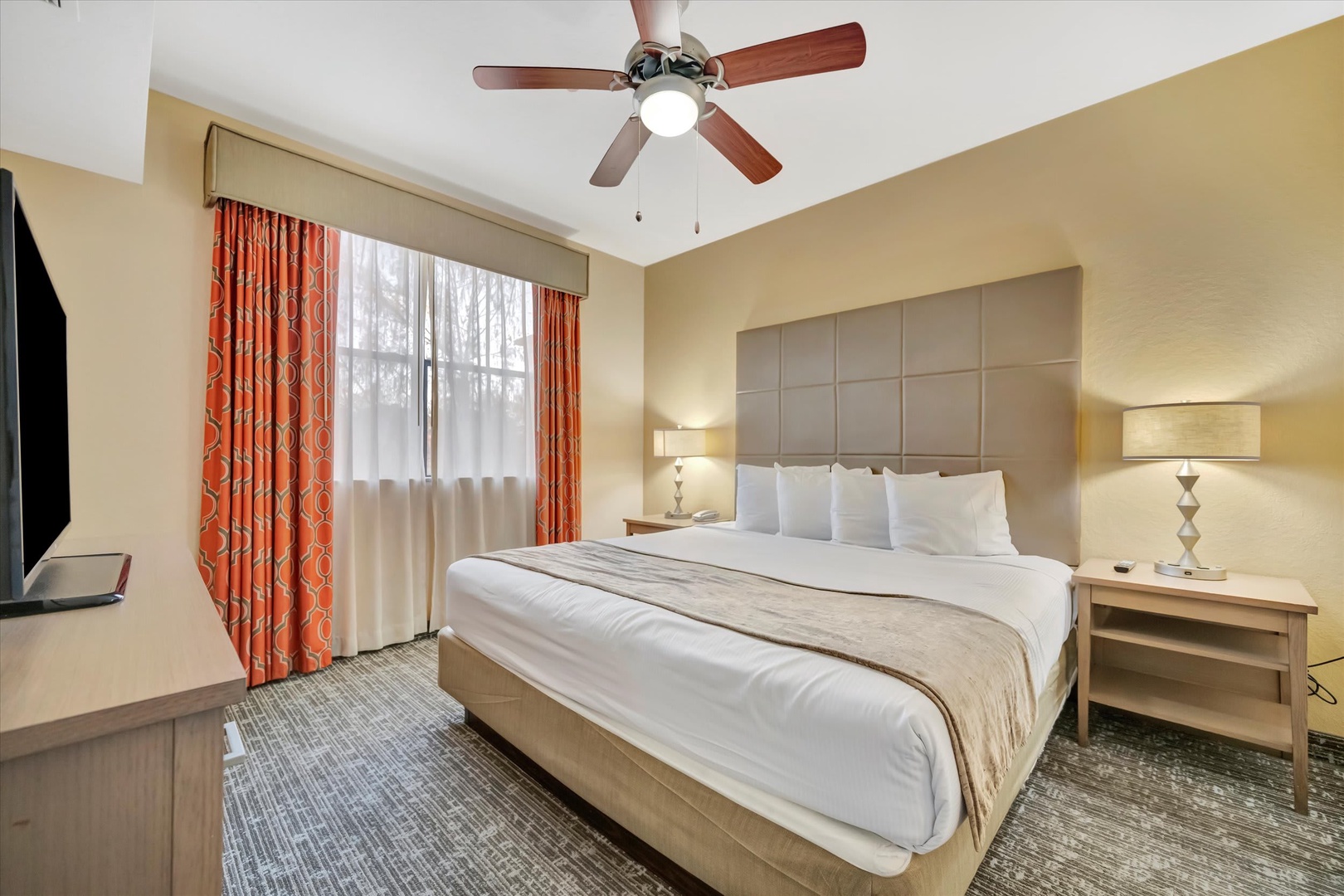 Sink into crisp linens and plush pillows after a day of exploring. Your room features a ceiling fan for comfort, warm lighting, and a welcoming atmosphere to help you rest and recharge.