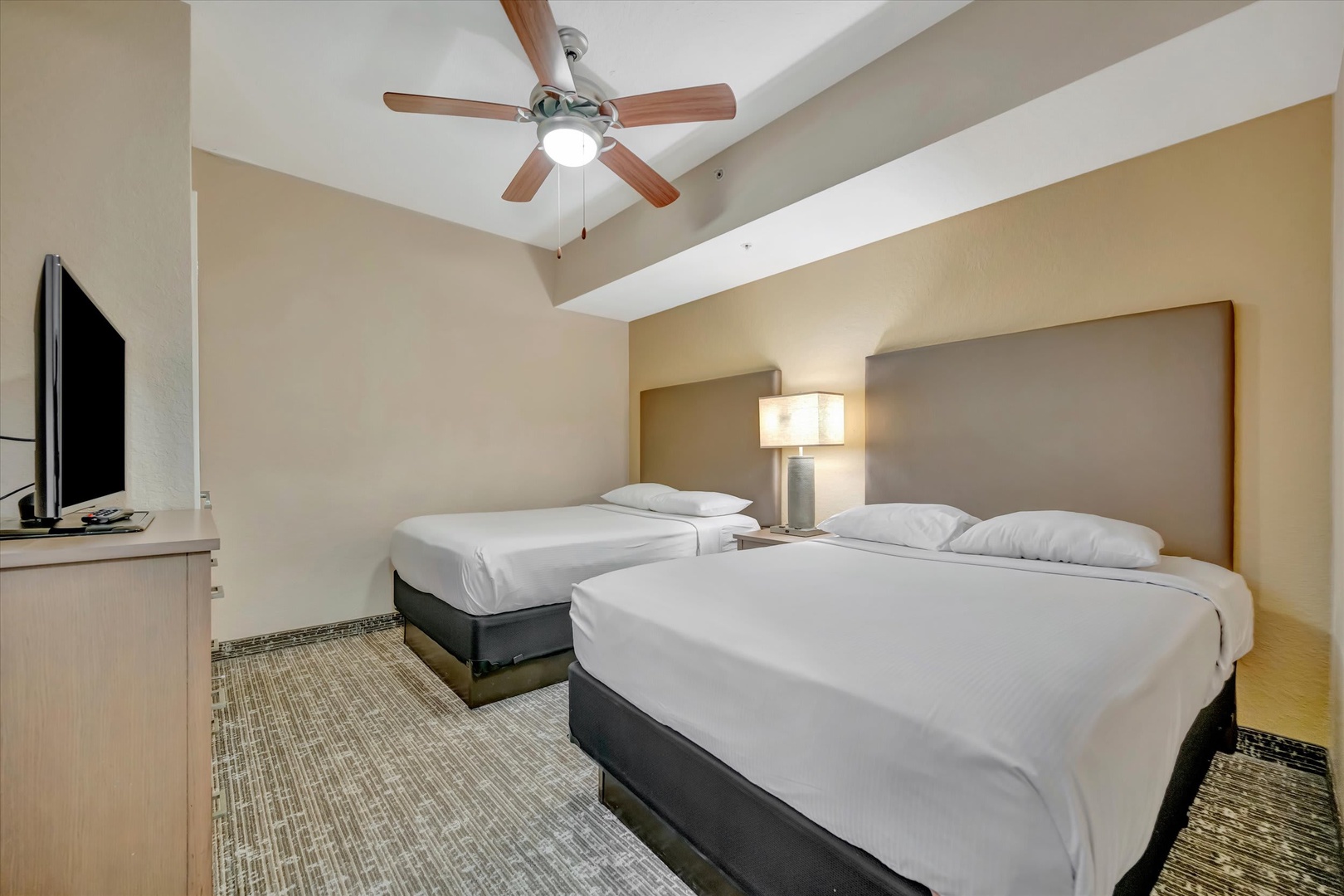 Sink into crisp white linens and enjoy your own space with two plush beds, a cozy ceiling fan, and everything you need for a restful stay.