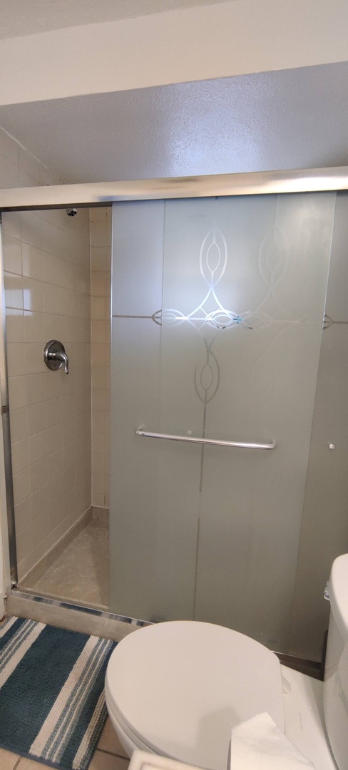 Step into your sleek, modern bathroom with a spacious glass-enclosed shower featuring elegant frosted detailing and gleaming fixtures.