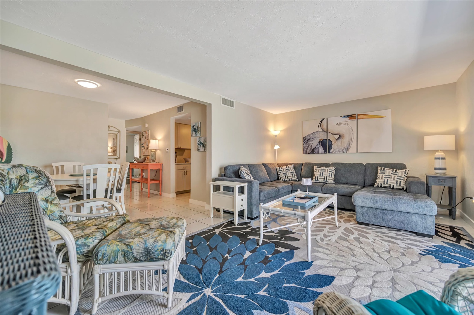 Sink into coastal-inspired comfort in your open living space, where soft lamps and patterned accents create a breezy, welcoming retreat after beach days.