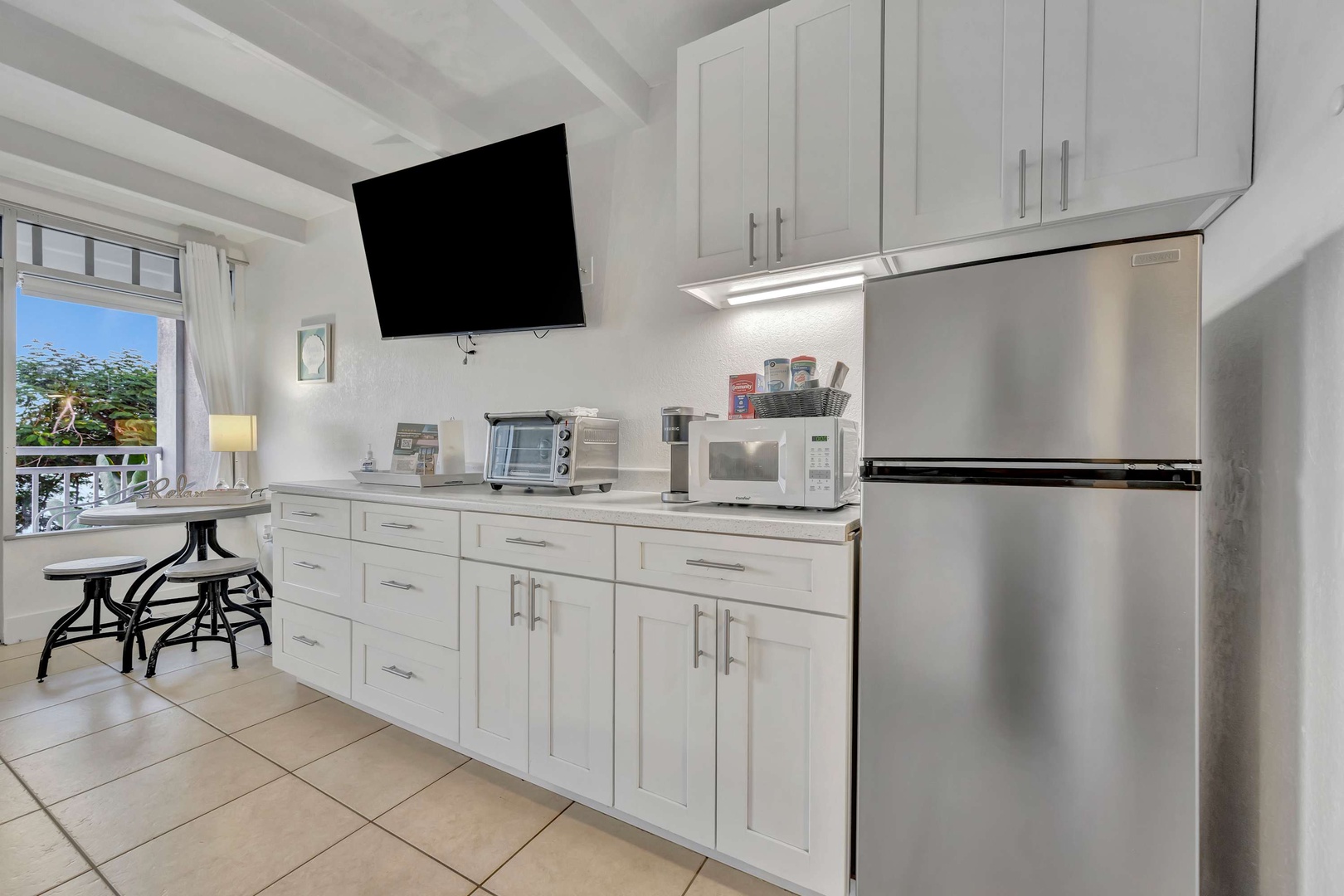 Your bright, modern kitchenette gives you everything you need to prepare meals at your leisure, with stainless steel appliances and crisp white cabinetry creating a welcoming space to cook and dine.