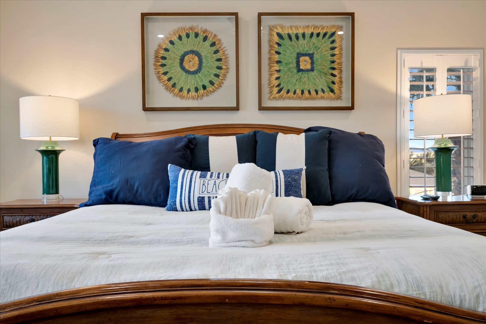 Sink into plush white bedding with crisp linens and beach-inspired accents, where coastal charm meets comfort in your peaceful retreat.