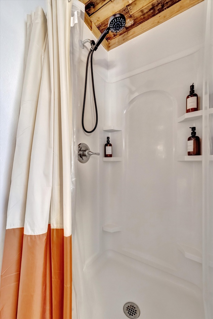 Refresh after your adventures in a crisp, clean shower with quality amenities and rustic wood beams overhead—your perfect mountain retreat awaits.