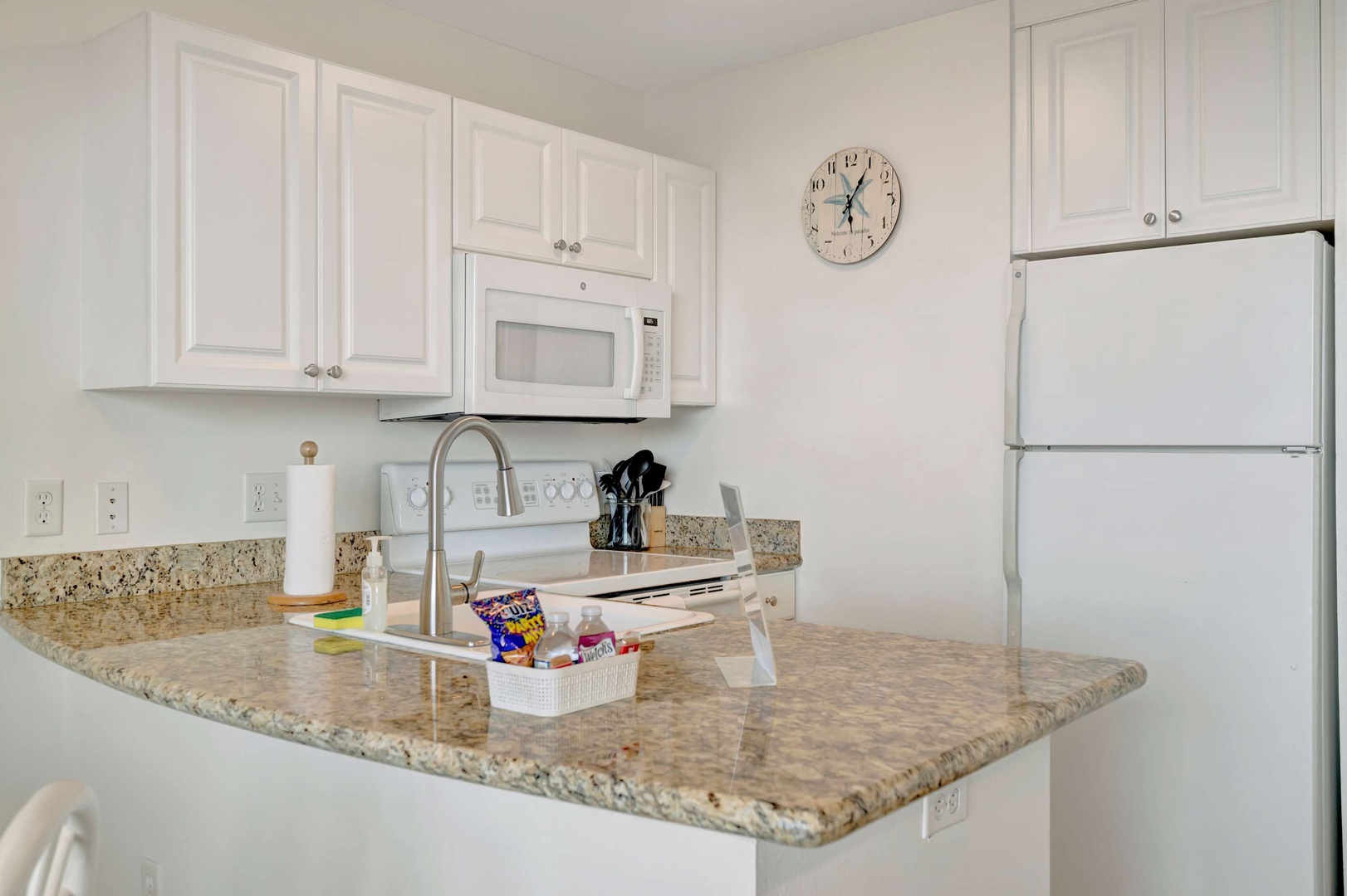 Your bright, modern kitchen features granite countertops, white cabinetry, and all the appliances you need to prepare meals during your stay.