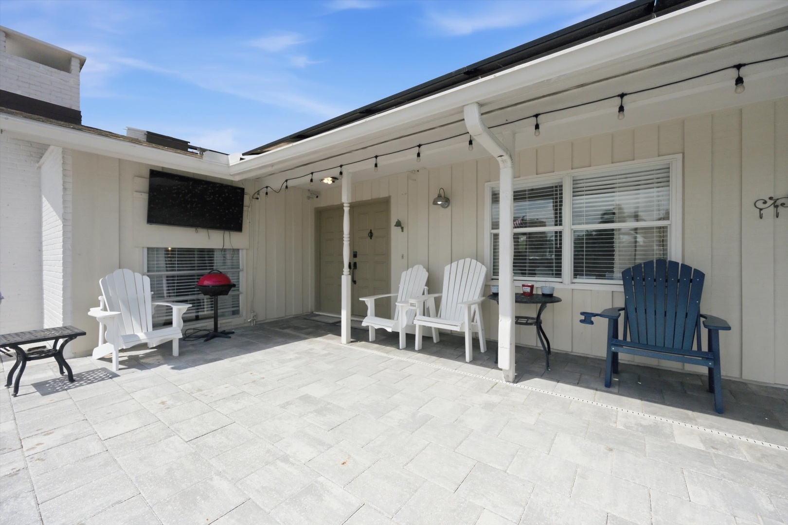Step onto your spacious covered patio, where Adirondack chairs and string lights create the perfect setting for morning coffee or evening conversations under the open sky.
