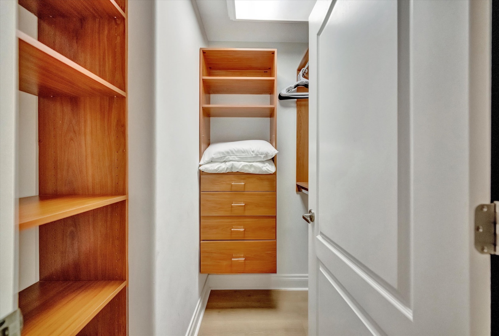 Bright, organized walk-in closet with built-in shelving and drawers keeps your wardrobe neatly arranged and easily accessible throughout your stay.