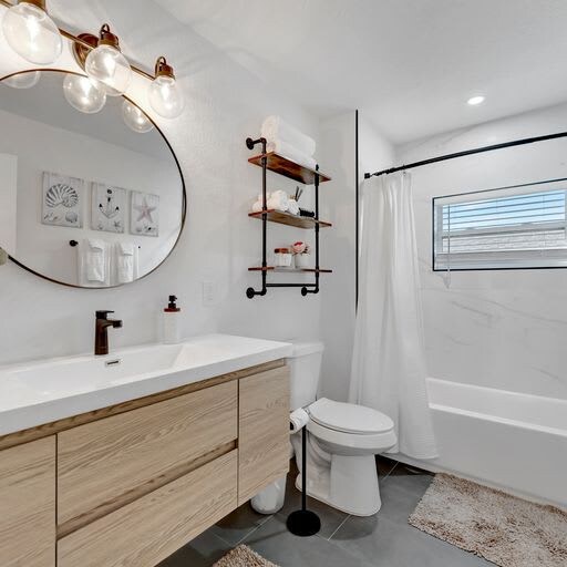 Step into your beautifully refreshed bathroom, where warm wood tones meet crisp white tile. Unwind in the tub after exploring, freshen up at the vanity, and enjoy modern touches like open shelving and stylish fixtures.