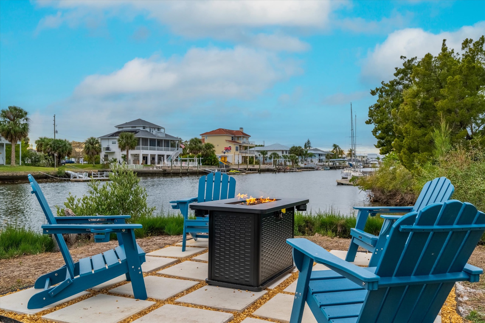 This waterfront coastal neighborhood features residential properties along a peaceful canal, with boat docks, palm trees, and charming homes lining the waterway, perfect for boating enthusiasts.