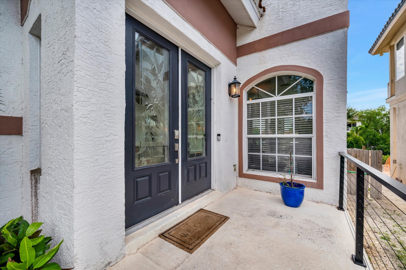 The front entrance features classic architectural details with decorative double doors, etched glass panels, and an arched window that adds timeless character to the exterior.