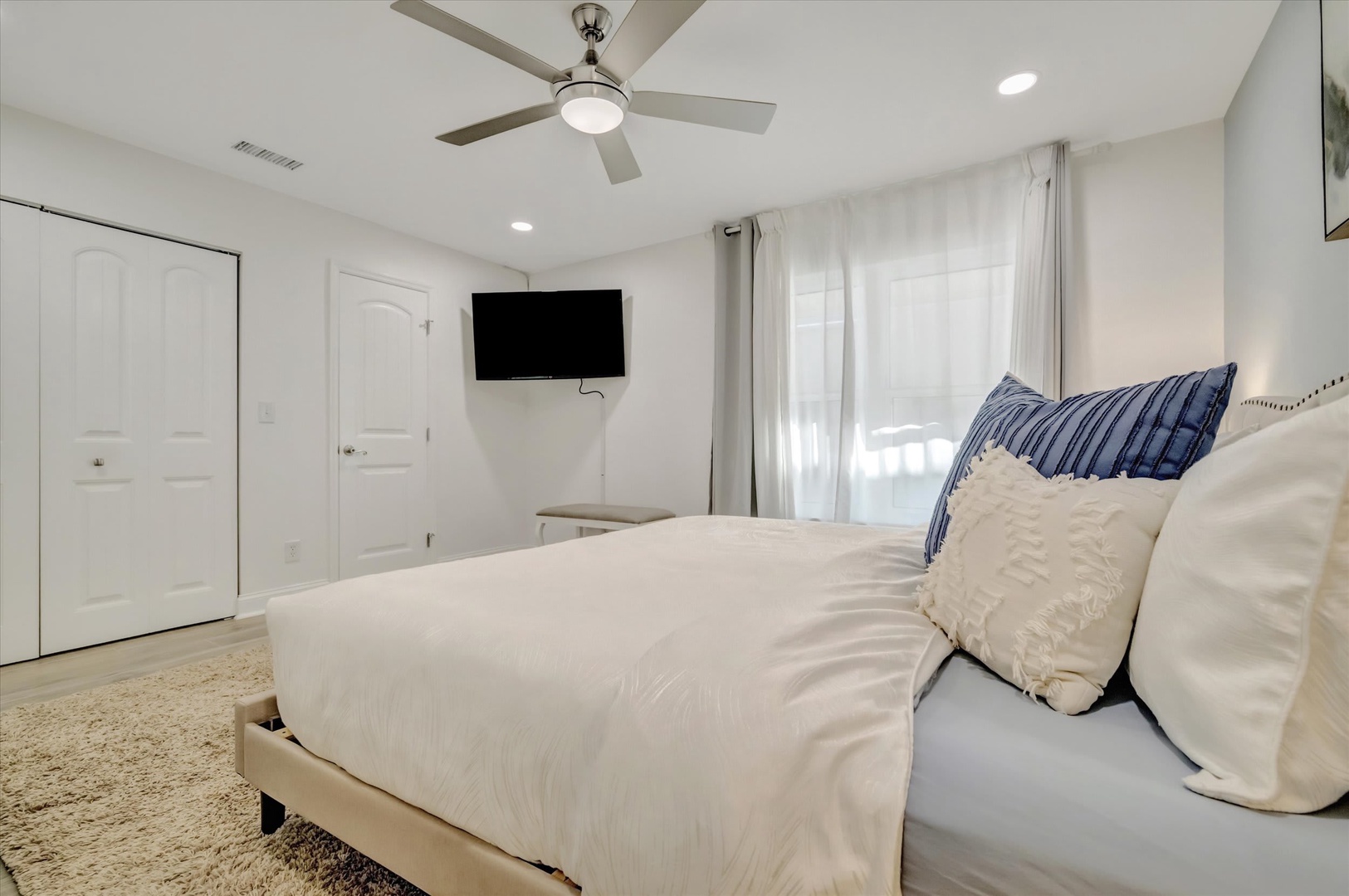 Sink into crisp white linens in your bright, airy bedroom. A ceiling fan keeps you cool, while the TV is ready for your favorite shows.