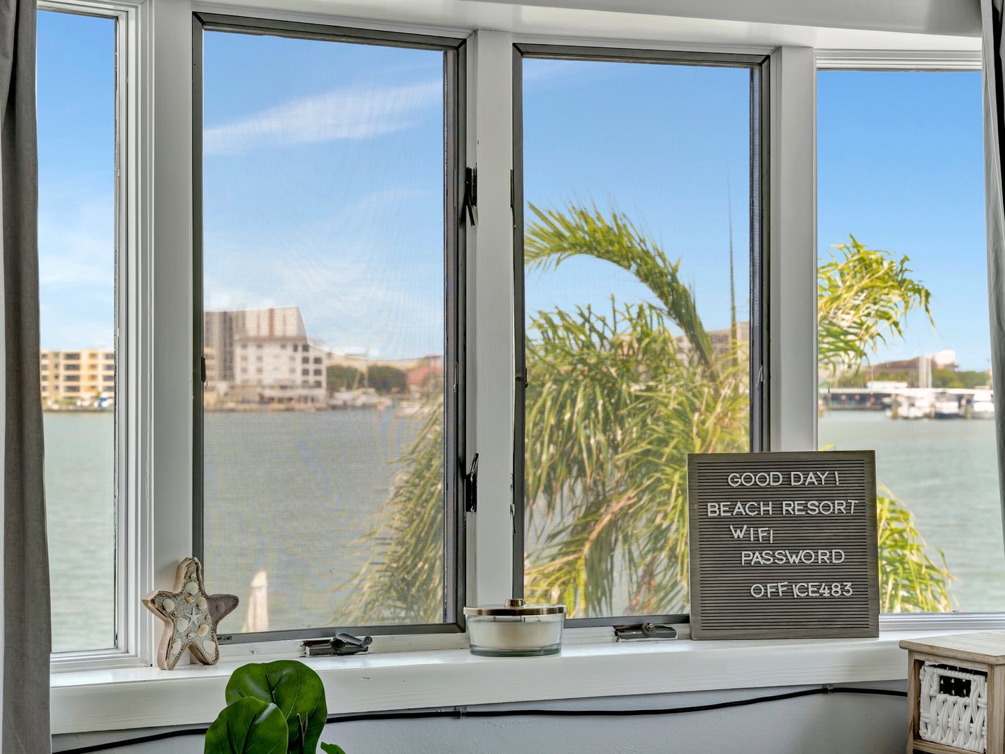 Open your window to sweeping waterfront views where gentle waves meet coastal buildings. A thoughtful welcome message and WiFi details await, making you feel right at home from the moment you arrive.