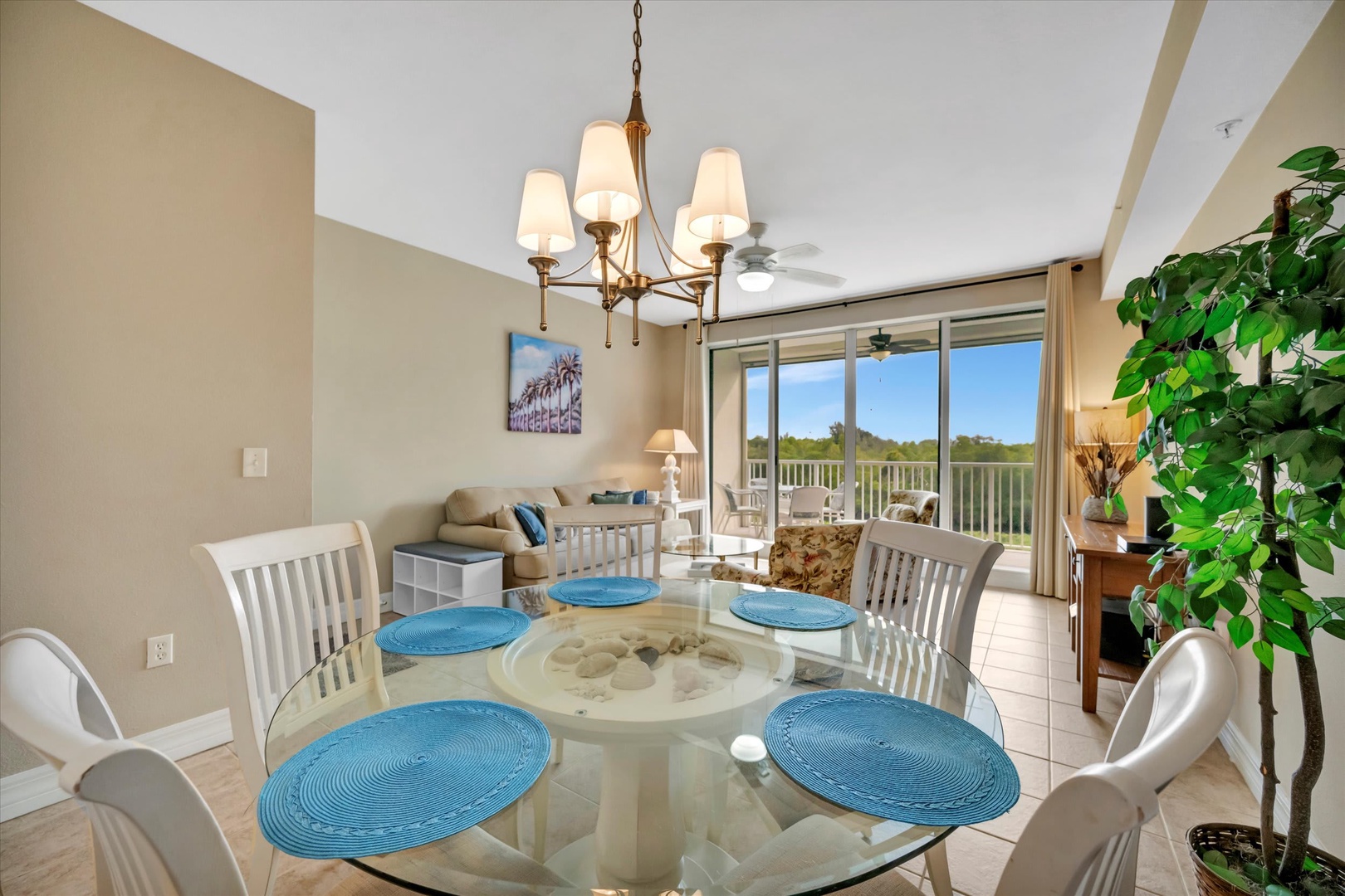 Gather around the glass dining table and picture yourself enjoying meals with natural light streaming through the balcony doors, offering a peaceful treetop backdrop beyond.