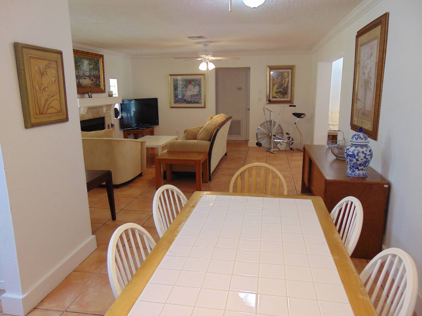 Gather around the spacious dining table for meals and memories, with a cozy living area just steps away featuring a fireplace and comfortable seating.