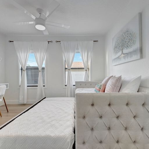 Sink into the plush, tufted bed and feel the soft breeze from the ceiling fan—your peaceful retreat awaits in this bright, airy bedroom.