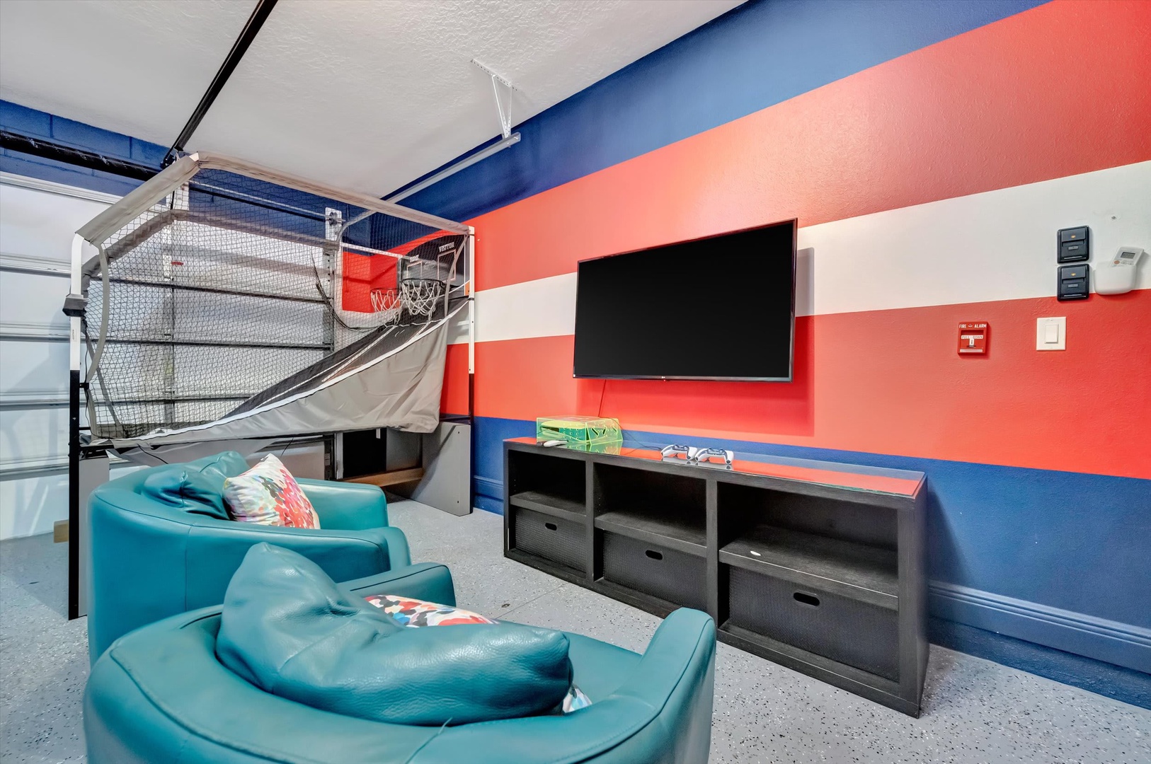 Shoot hoops and unwind in your own game room, complete with a basketball setup, comfy seating, and bold colors that bring energy to every moment.
