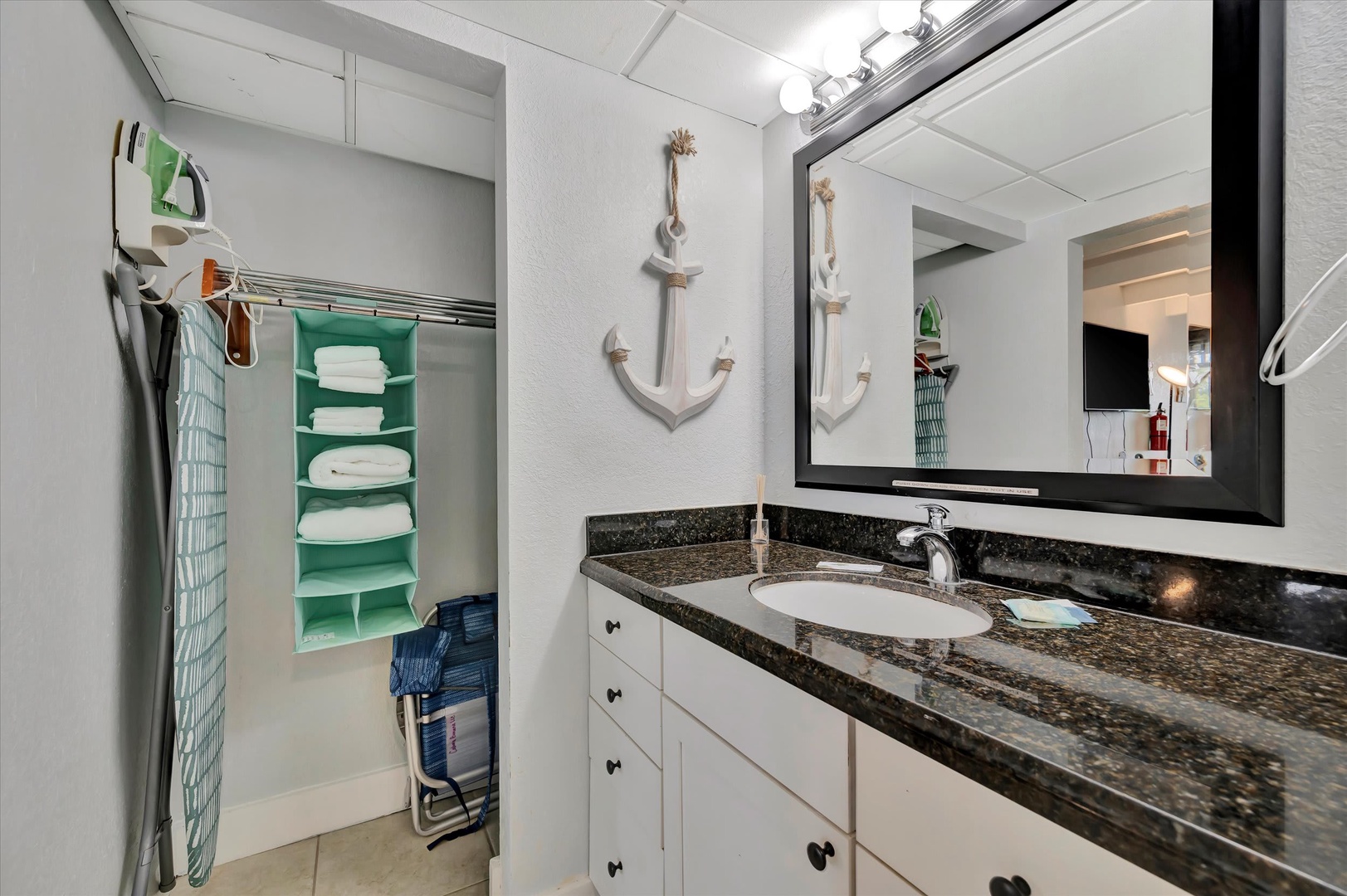 Freshen up in your coastal-inspired bathroom with granite counters, crisp white cabinetry, and nautical anchor accents—all your essentials organized and within reach.