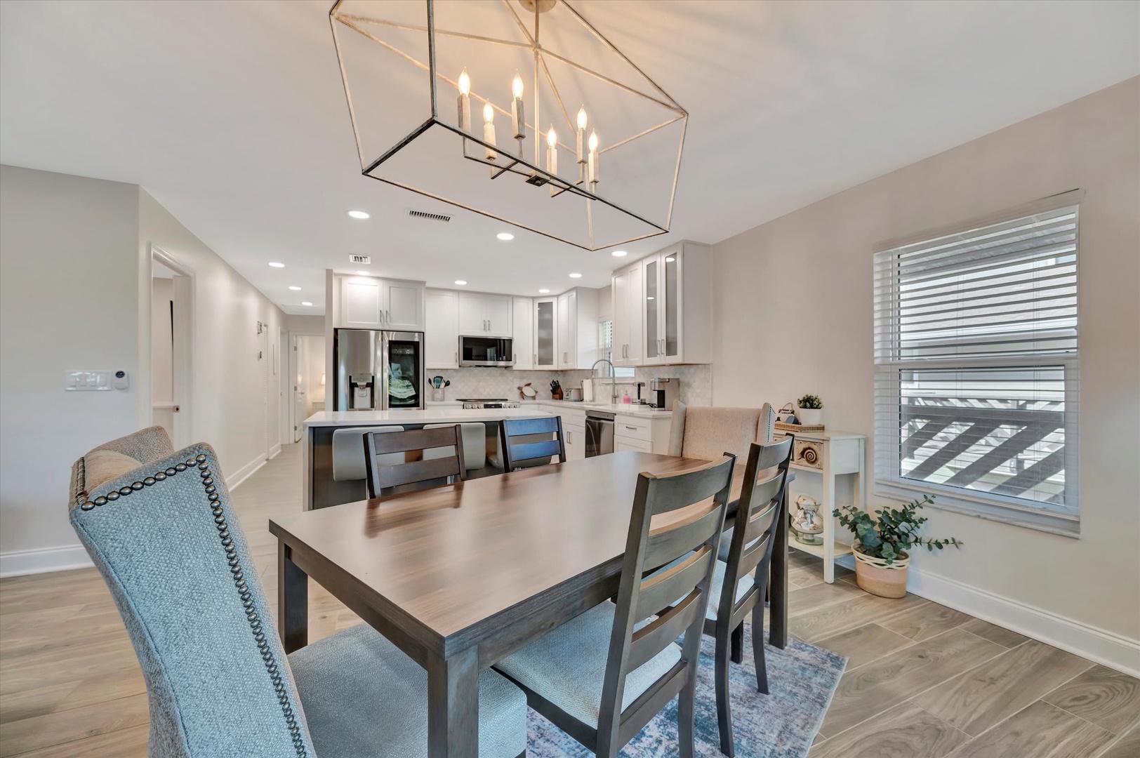Picture yourself gathered around this elegant dining table, sharing meals under the warm glow of the statement chandelier. The open-plan kitchen invites you to cook together, while abundant natural light fills your space throughout the day.