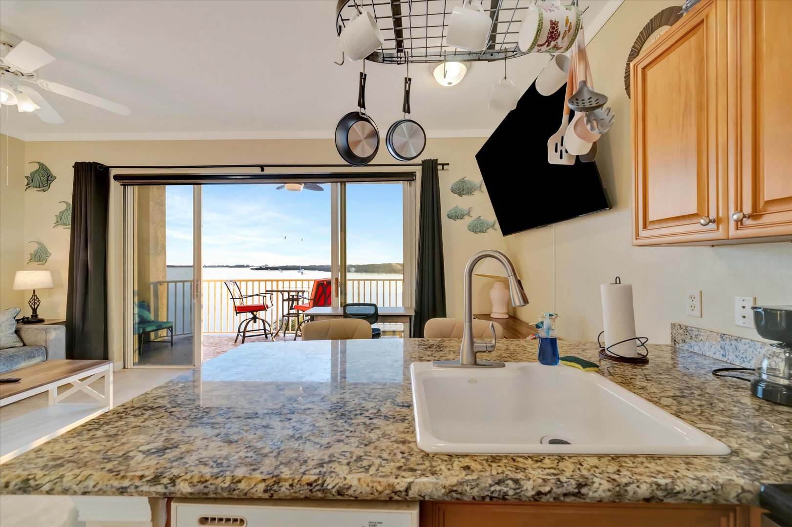 Bright, well-equipped kitchen with spacious granite counters and stunning lake views from the balcony doors—the perfect space for cooking and morning coffee.