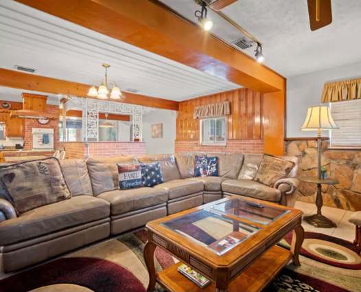 Sink into plush seating in your spacious living area, featuring warm wood accents, exposed beams, and charming cabin-style décor that invites you to unwind.
