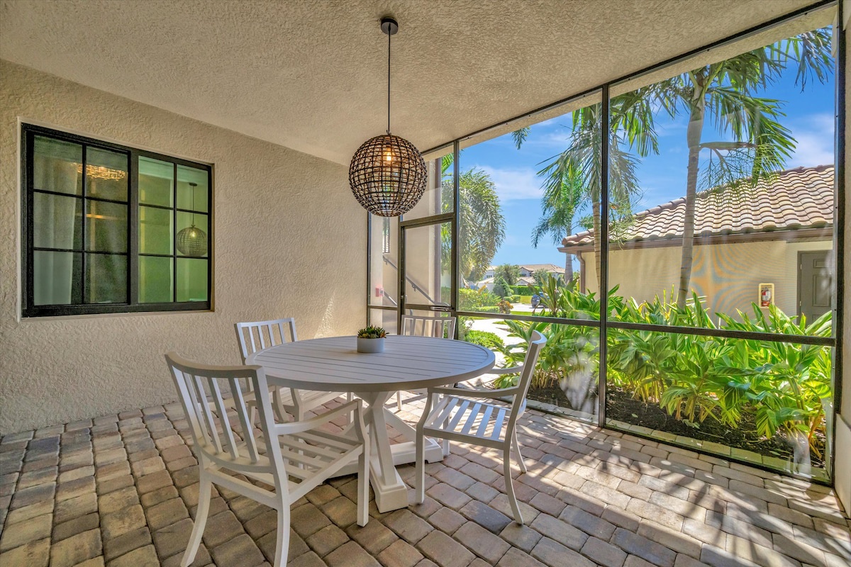 Enjoy your morning coffee or evening meals in this breezy screened patio, where sunlight filters through the palms and your private dining area invites relaxed conversation.