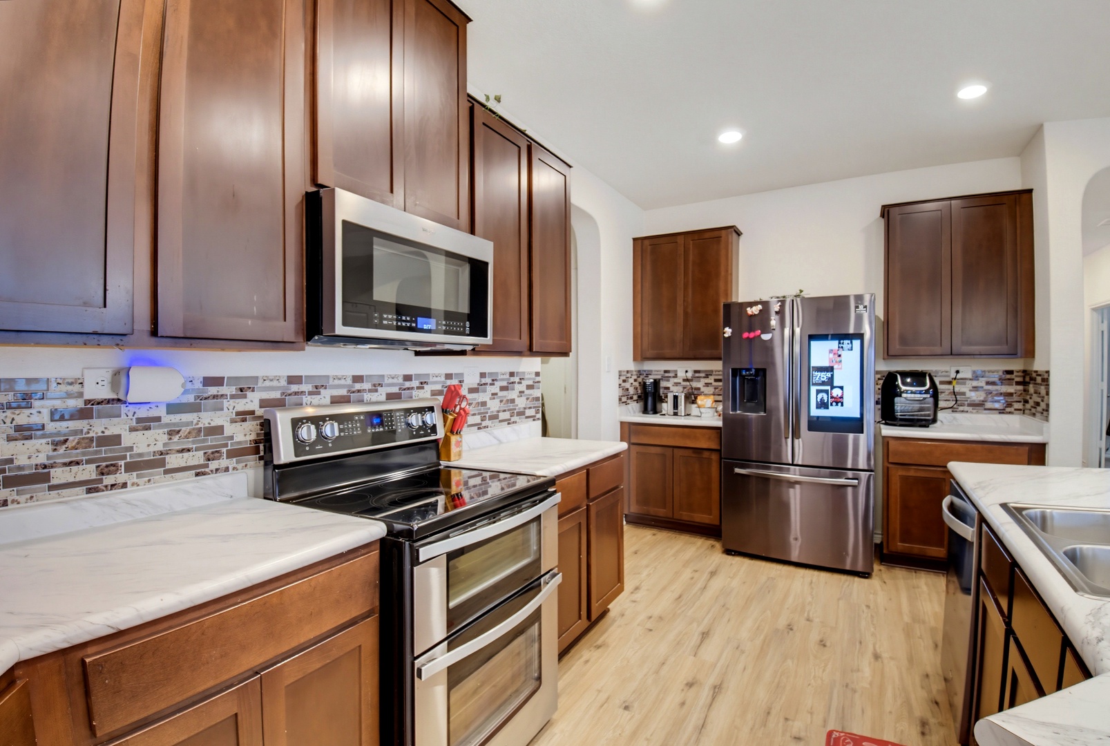 Step into your fully equipped kitchen with warm wood cabinetry, modern stainless steel appliances, and plenty of counter space for preparing home-cooked meals during your stay.