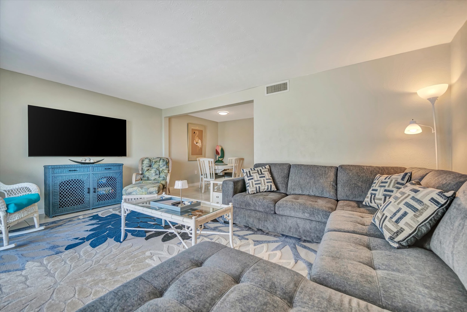 Stretch out on plush seating in your open-concept living area, where soft coastal colors and elegant decor create a calm, inviting retreat. Perfect for unwinding together after a day of adventures.