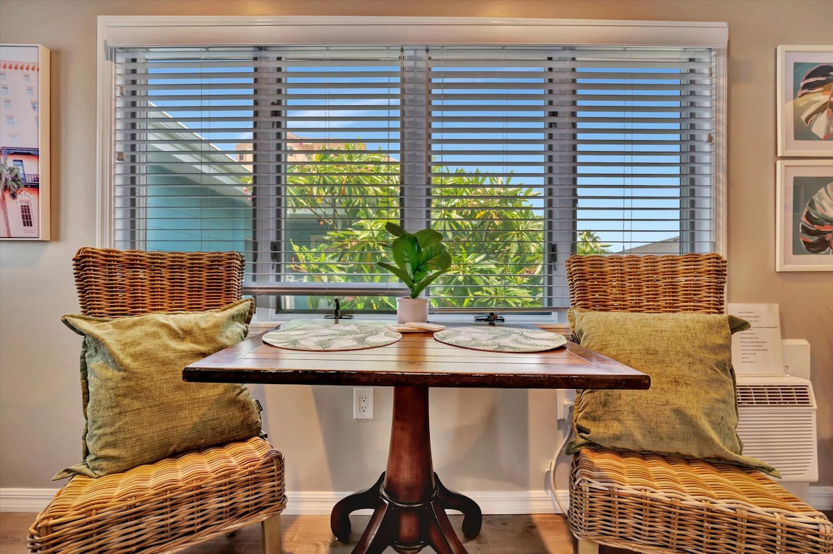 Settle in for breakfast at your charming bistro table, where wicker chairs and warm wood create a cozy nook flooded with natural light and garden views.