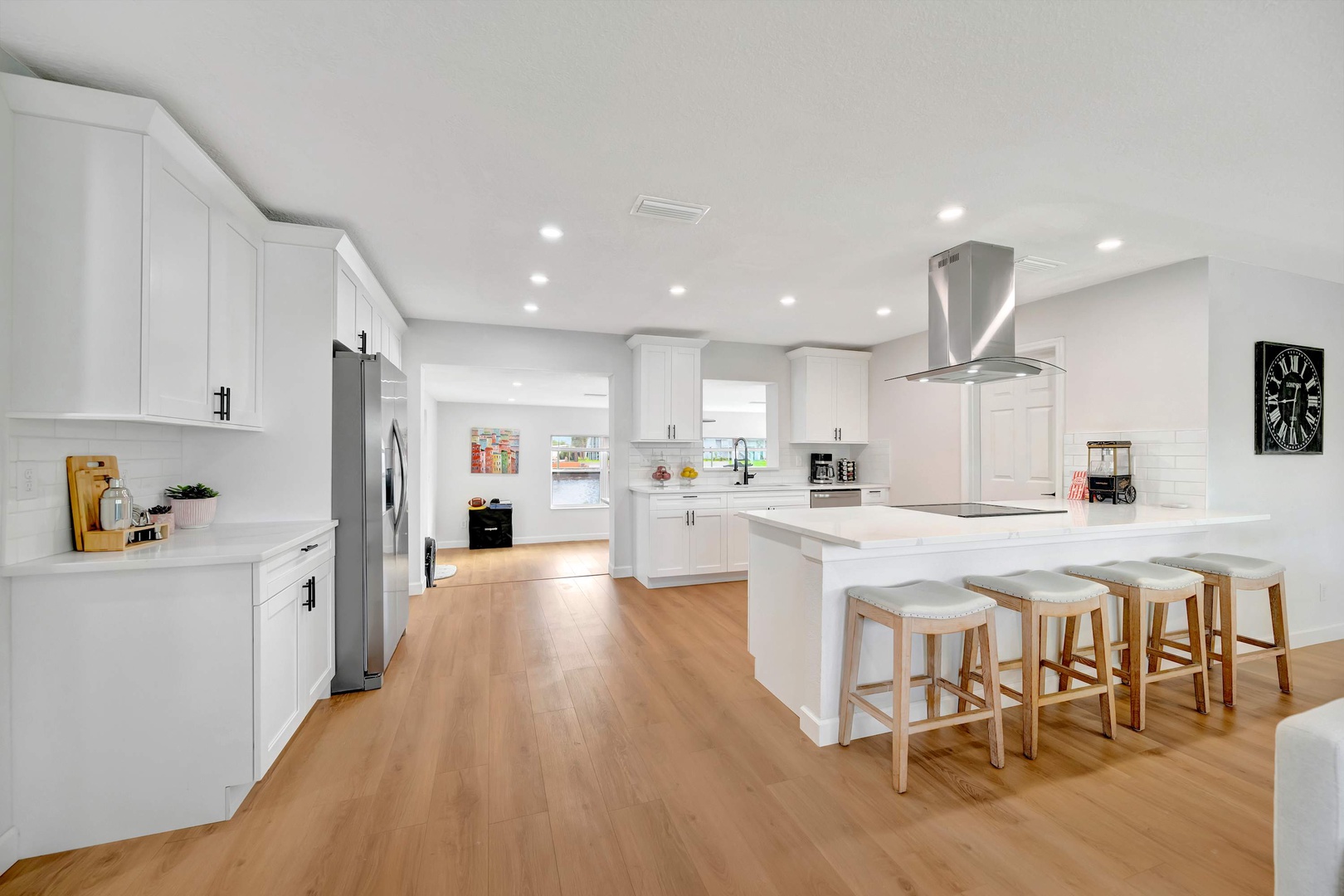 Bright, spacious kitchen with crisp white cabinetry and gleaming countertops. The inviting island with casual seating is perfect for morning coffee and family gatherings.
