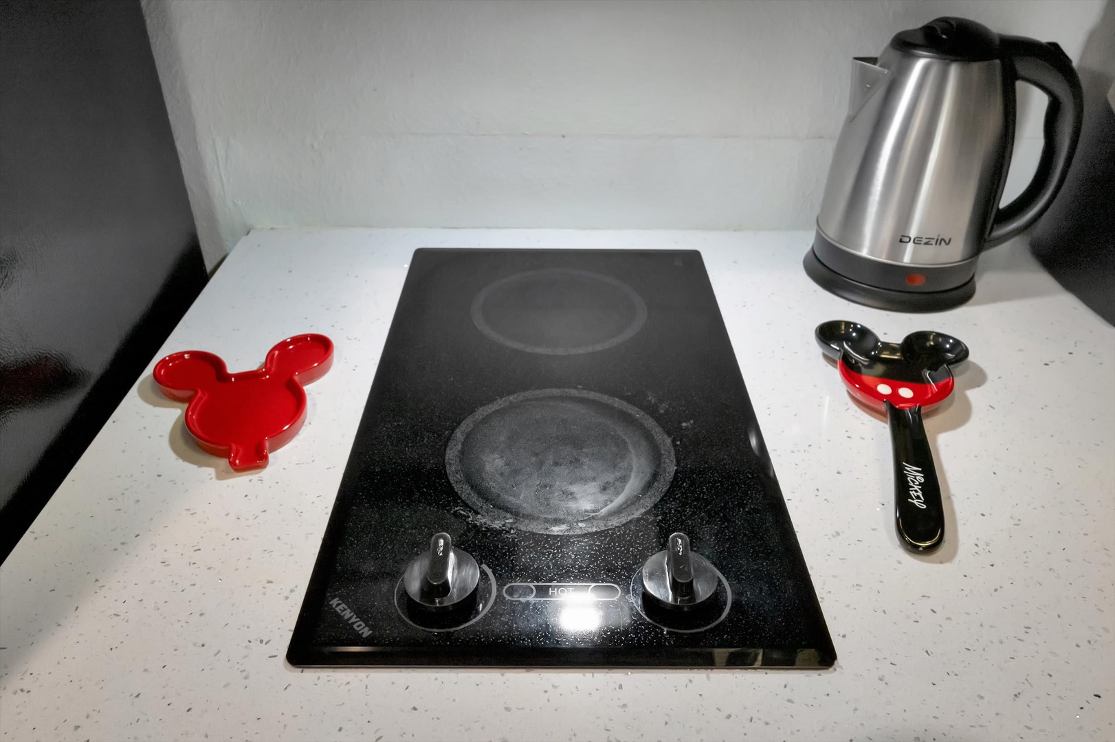 A sleek stovetop ready for your culinary adventures, complete with a kettle and playful Mickey Mouse accessories to make your stay extra special.