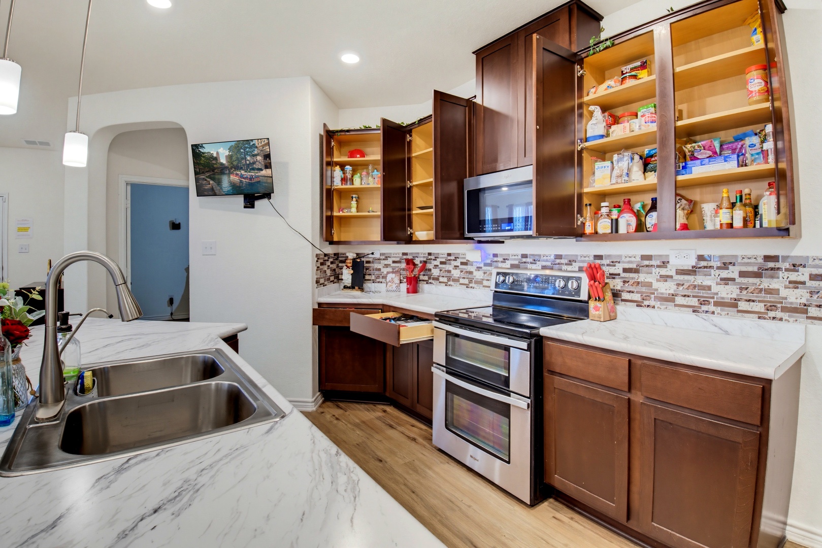 Your full kitchen awaits with sleek marble counters, stainless appliances, and warm wood cabinetry stocked and ready for your culinary adventures.