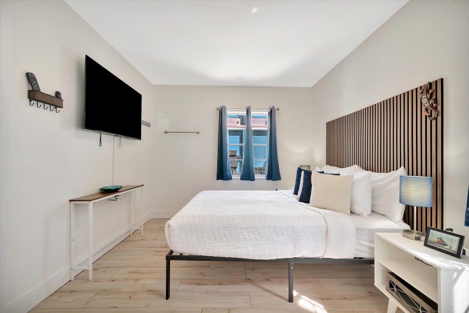 Sink into crisp white linens and unwind in your bright, modern bedroom with natural light streaming through the window and all the comforts of home.
