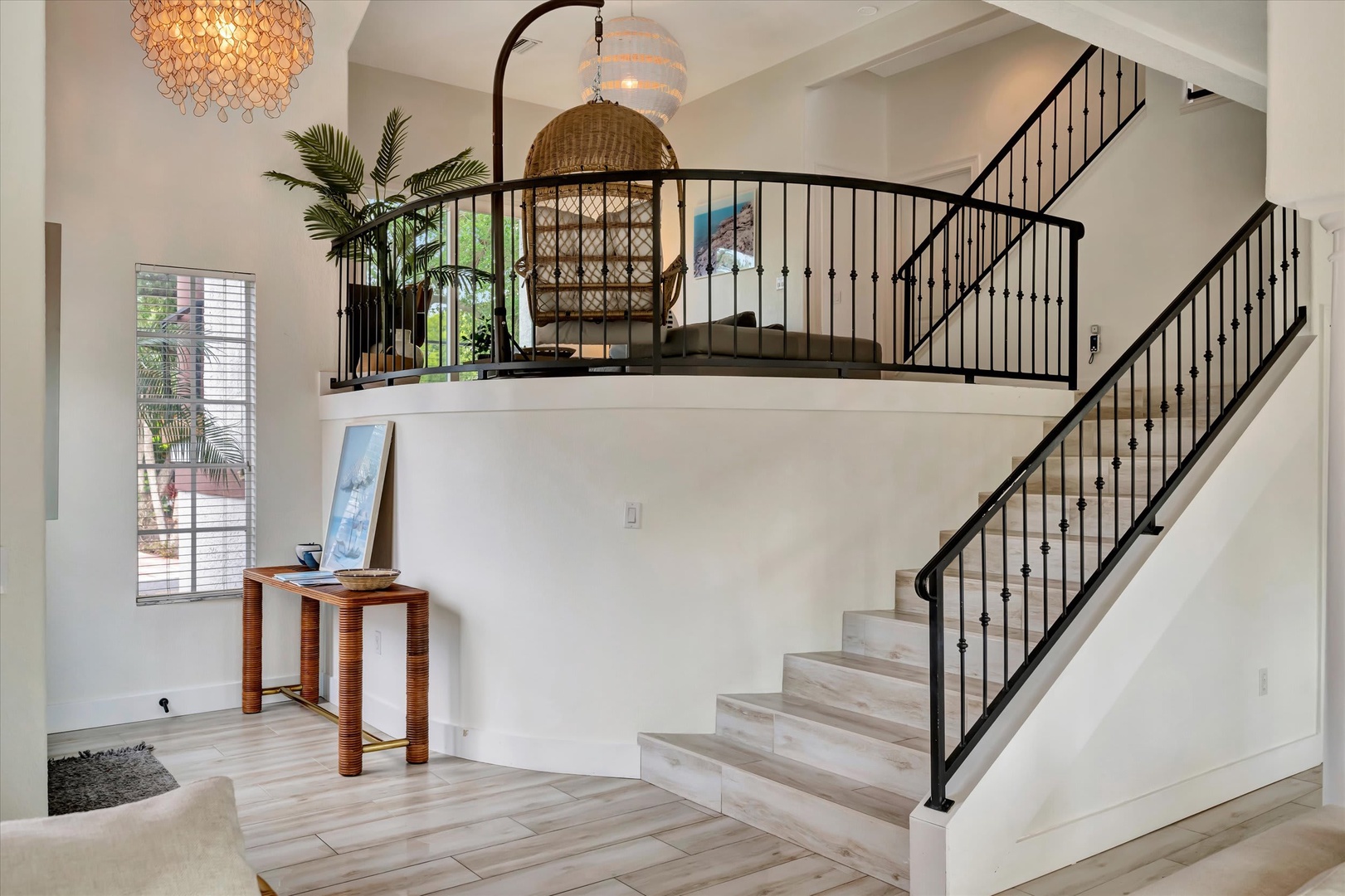 Step into your airy retreat where coastal elegance meets thoughtful design. Soft natural light pours through large windows as a striking staircase leads to your private loft sanctuary, complete with a cozy reading nook.
