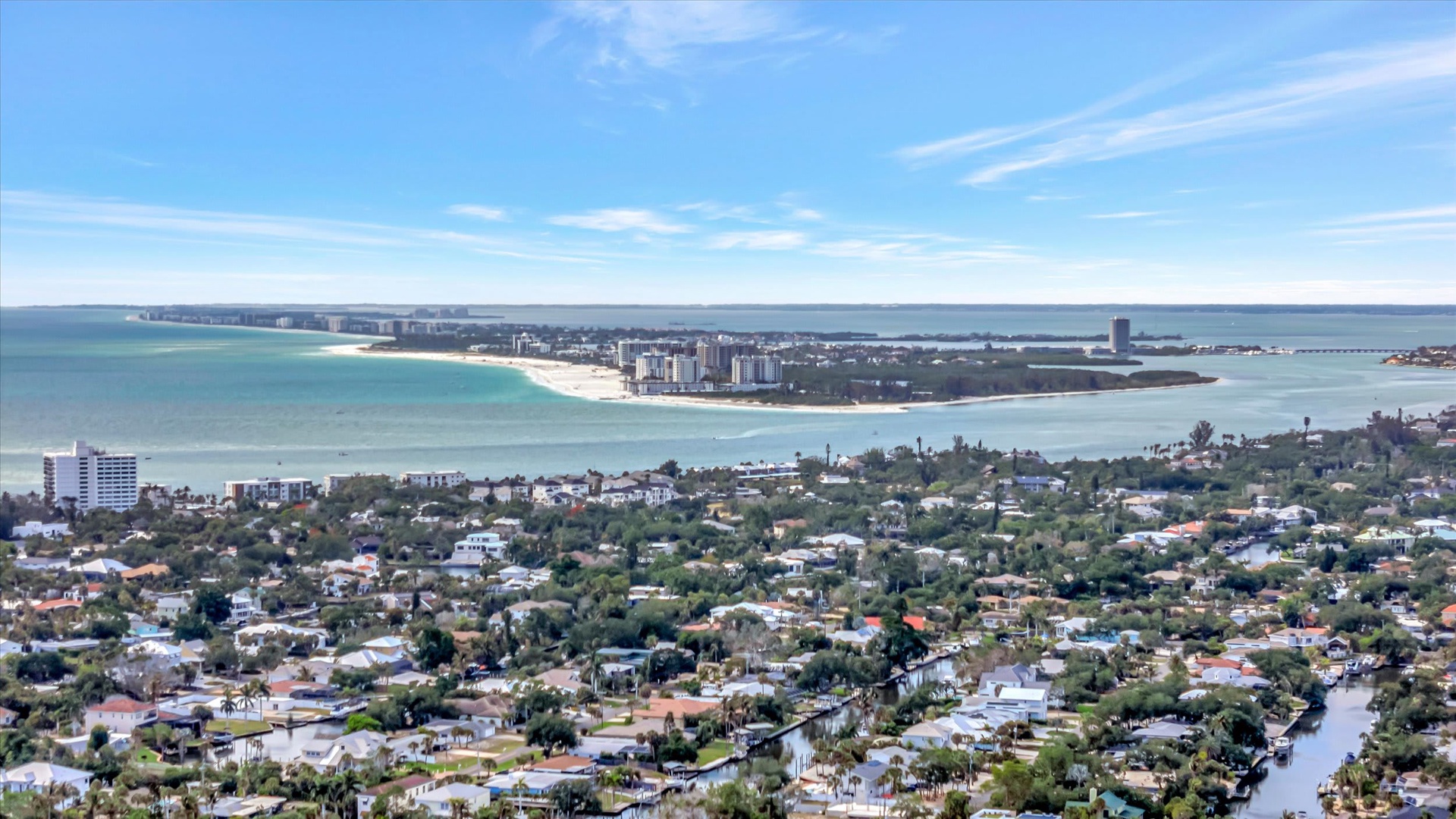 Aerial view showcasing the coastal setting, with sandy beaches, waterfront communities, and tranquil bay waters defining the surrounding area.