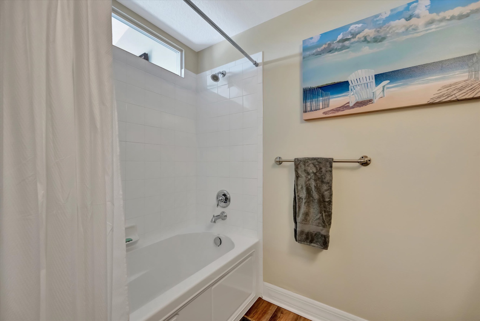 Step into your bright, spotless bathroom with a full tub-shower combo and fresh towels waiting. The skylight floods the space with natural light, making mornings feel effortless.