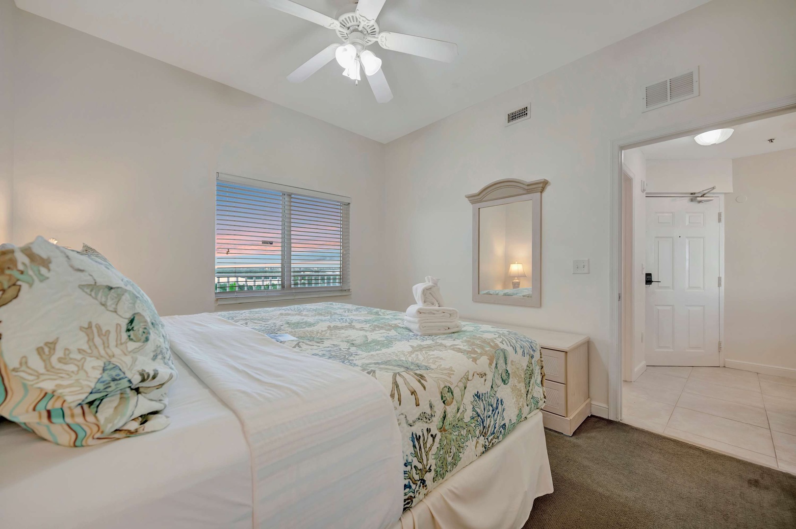 Drift off in your peaceful coastal retreat with vaulted ceilings, ocean-inspired bedding, and a gentle ceiling fan breeze to keep you comfortable.