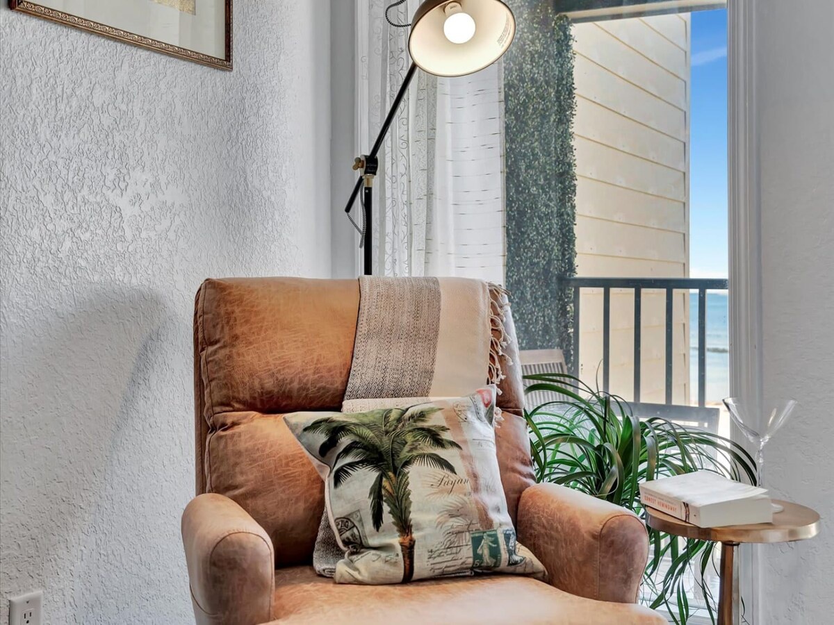 Curl up in your cozy reading nook with natural light streaming through the balcony doors and ocean views just beyond. The perfect spot to unwind with a book and the sound of waves.