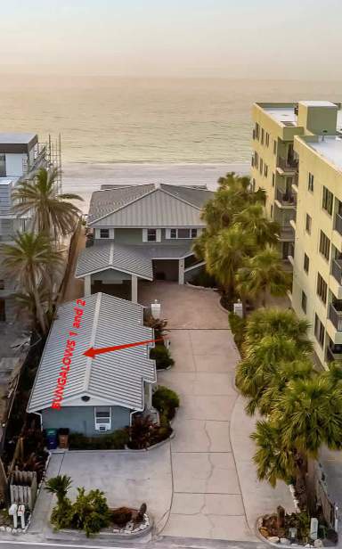The property sits just steps from the ocean, surrounded by palm trees and neighboring beachfront buildings. A perfect coastal location for your seaside getaway.