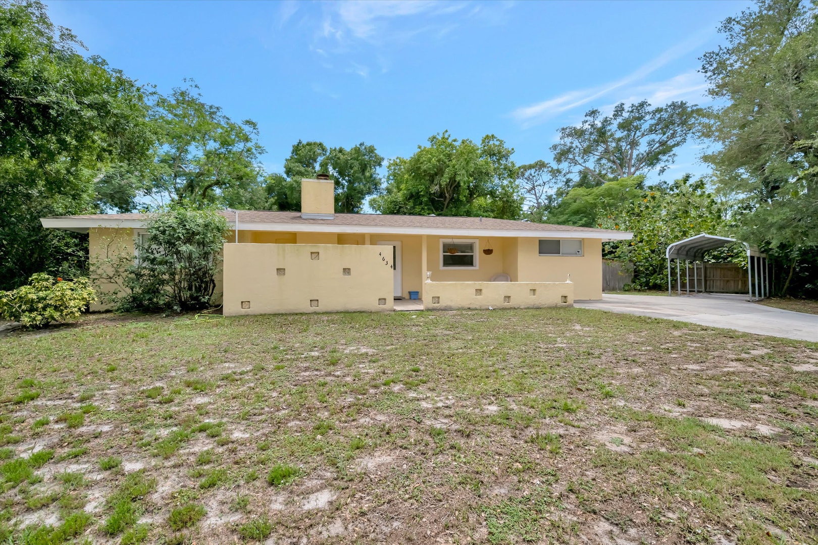 A charming mid-century home set on a spacious lot, surrounded by mature trees and plenty of greenery, offering covered parking and private outdoor space.