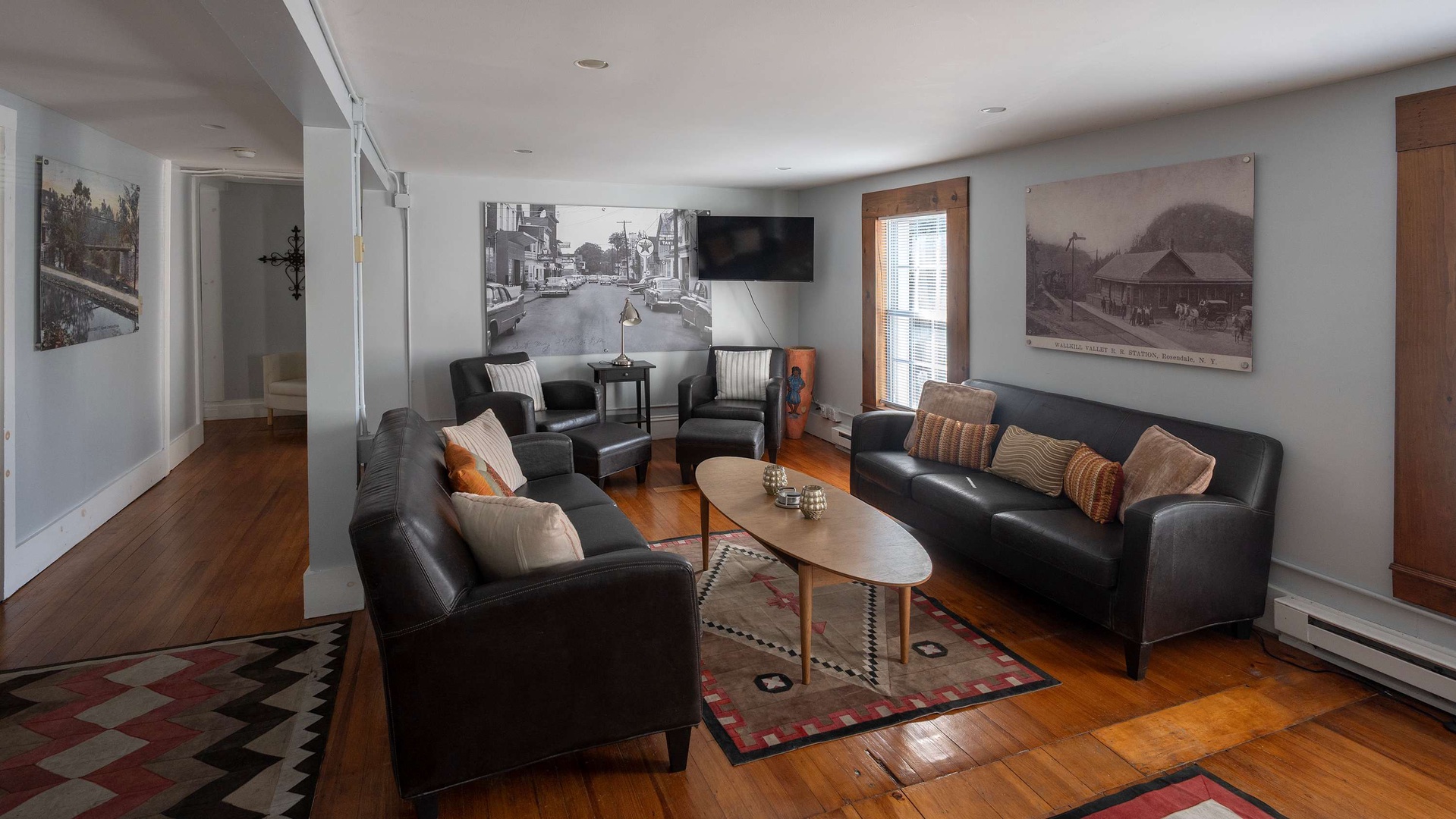 Unwind in this inviting living room, where vintage photography and plush leather seating create a warm, nostalgic gathering space for your group.