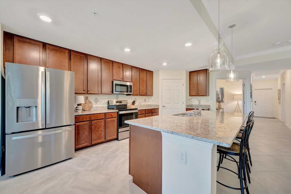 Step into your spacious gourmet kitchen, where sleek granite countertops meet warm wood cabinetry. The large island invites you to gather, cook, and create memories in this bright, beautifully designed space.